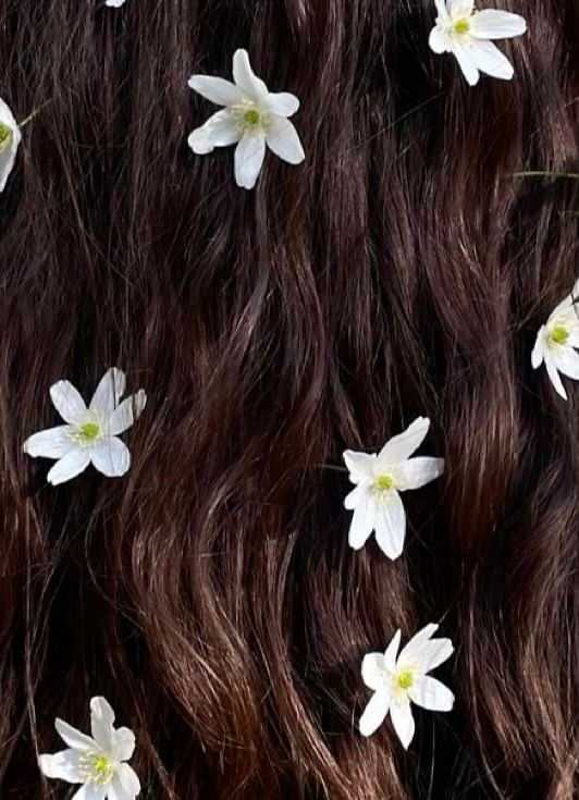 Dark brown hair with small white flowers woven throughout.