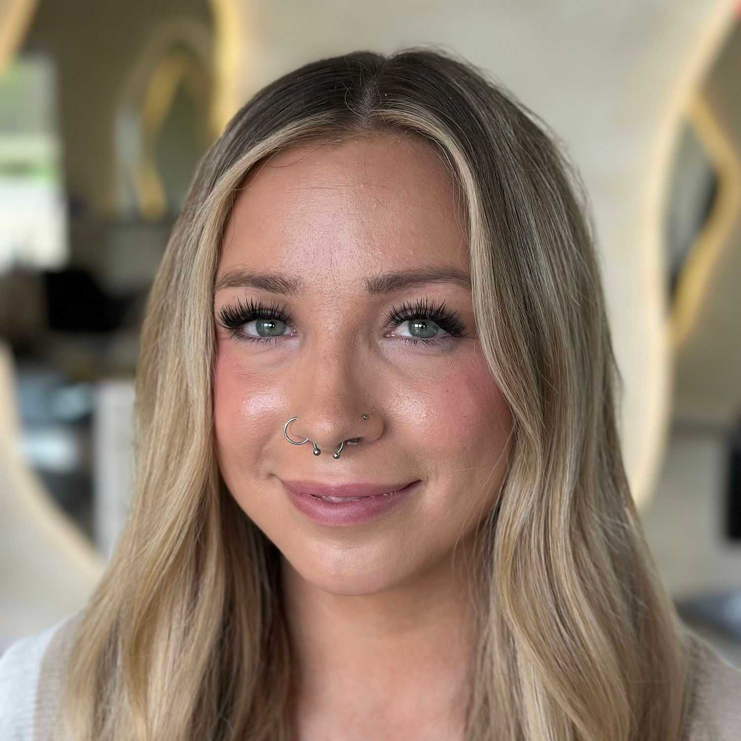 Portrait of Cas, a professional stylist at Stella Beauty, showcasing their expertise and style.